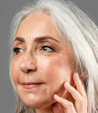 Older woman with hand on face
